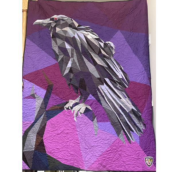 Quilt of a Raven - black and white raven on a multi-hued purple background.