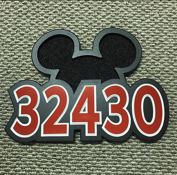 Sign by Mastyl Signs. Black, red, and white. Shows Mickey Mouse ears, and red and white numbers "32430".