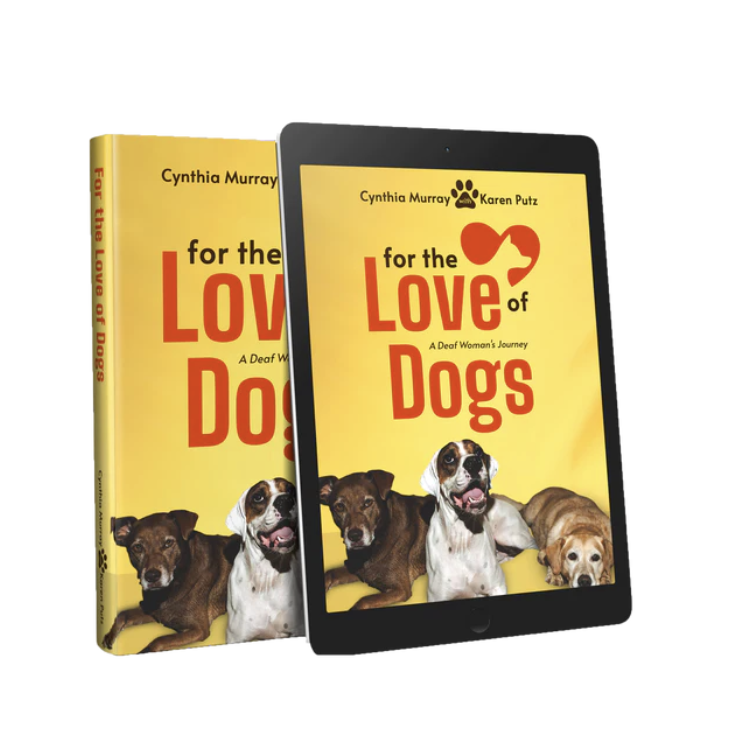 Book and iPad - both showing cover of "For the Love of Dogs, a Deaf Woman's Journey", by Cynthia Murray and Karen Putz. Yellow book cover with three dogs.